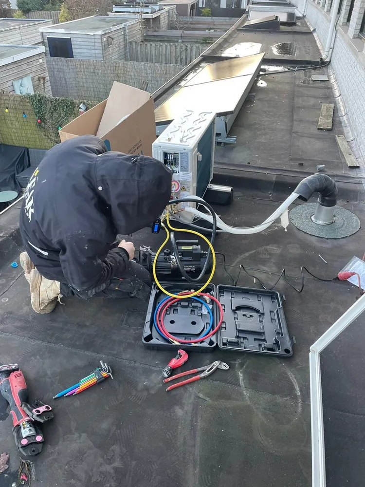 Montage van een airco buitenunit op een dak