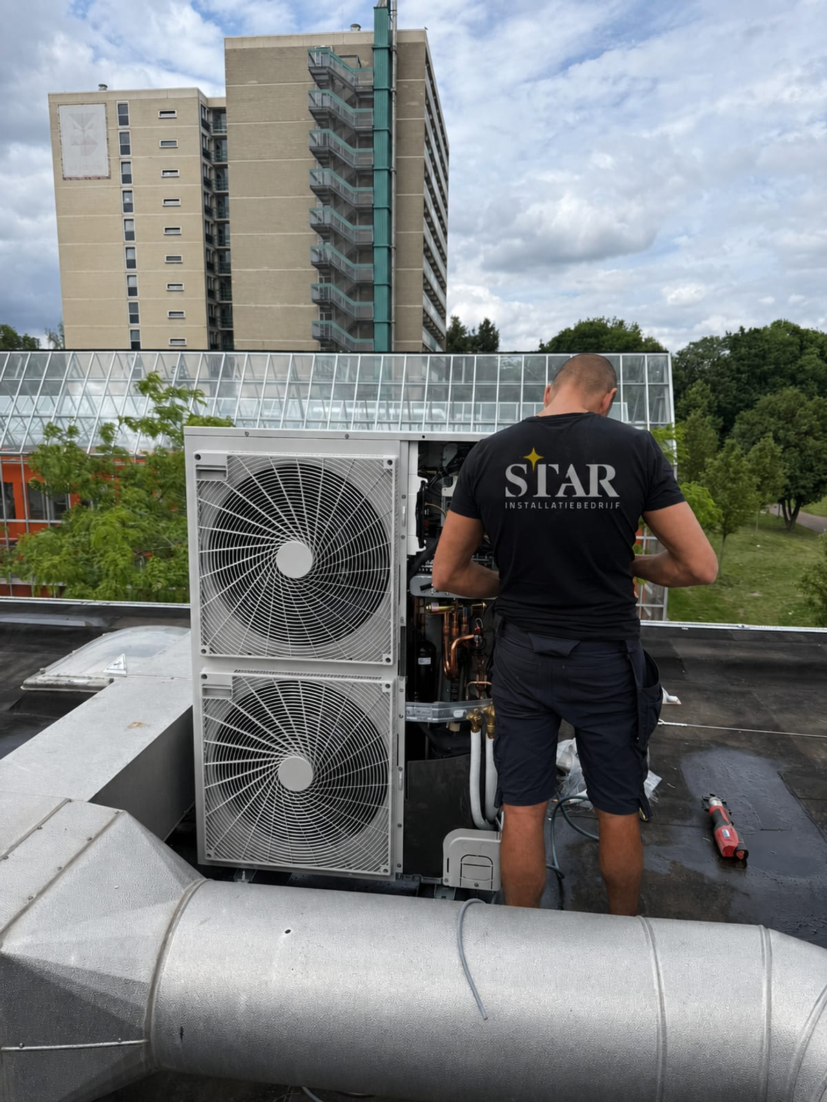 Monteur van Star Installatie bij een airco buitenunit op een dak