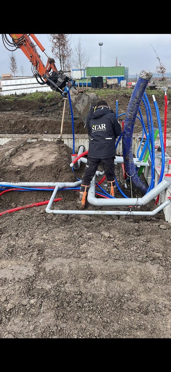 Monteur van Star Installatie sluit leidingen aan voor stadsverwarming