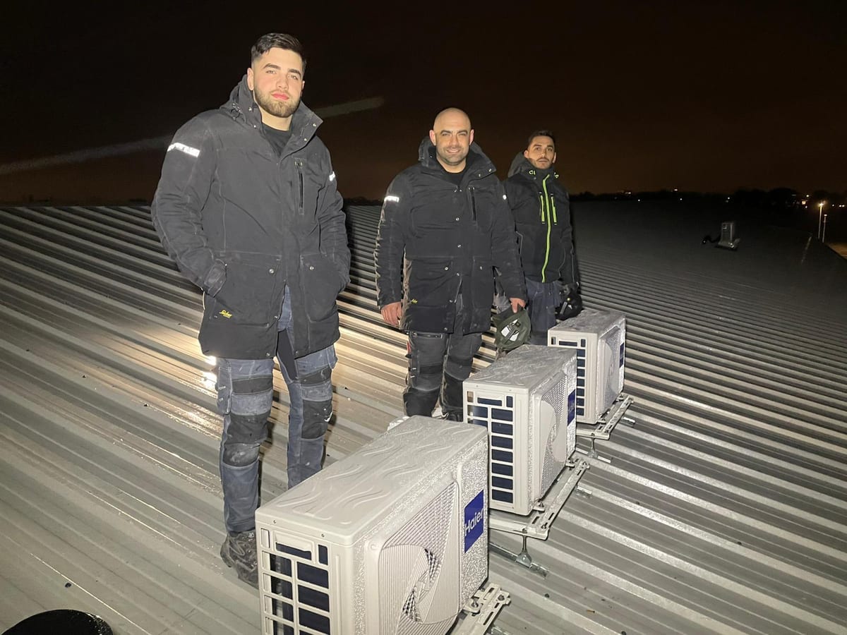 Drie vakmensen van Star Installatie bij een rij airco buitenunits op een dak